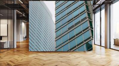 contrast of the glass facade of two skyscrapers with edges and curvature Wall mural