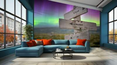 god created it text quote on wooden signpost with aurora borealis in the background. Wall mural