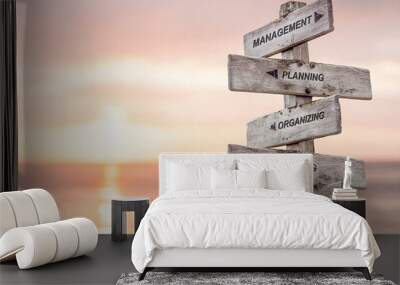 management planning organizing leading controlling text engraved on wooden signpost at the beach during sunset. Wall mural