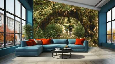 Mother and son hiking under natural archway in the Hoh Rainforest in Olympic National Park Wall mural