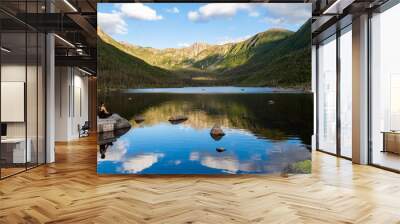 Young WOman sitting alone in front of the lake of the Americans, in the Gaspésie national park, Canada Wall mural