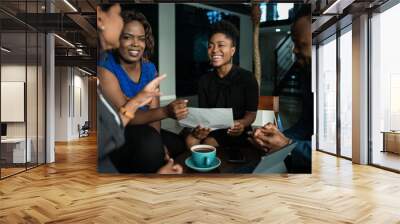 African businesspeople laughing together during an office meeting Wall mural