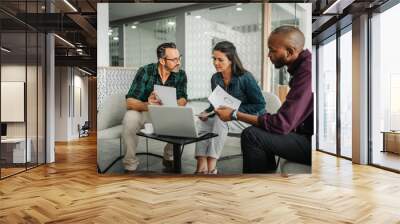 Casual meeting of diverse business team analyzing financial data Wall mural