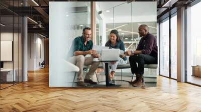 Casual meeting of smiling diverse business team analyzing financial data Wall mural