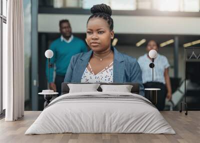 Confident african business woman wallking out of the office with coleagues behind her Wall mural