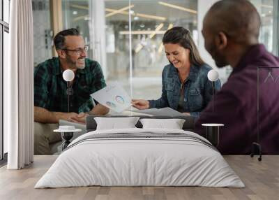 Happy smiling successful business colleagues having a candid seated casual meeting Wall mural