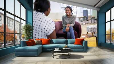 Job interview in co-working space by recruiter. Black african woman in her twenties being interviewed by a woman employer Wall mural