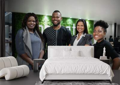 Smiling African businesspeople standing in the lobby of their office Wall mural