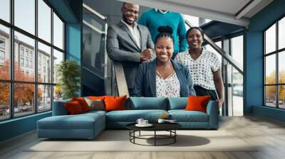 Team of african business people smiling and standing on stairs in a modern office Wall mural