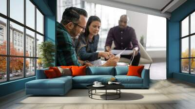 Three diverse businesspeople going over paperwork in an office l Wall mural