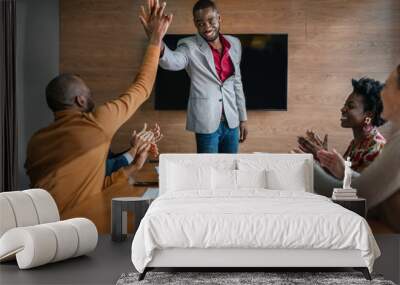 Two African businessmen giving high five while diverse South African coworkers clapping in congratulations Wall mural