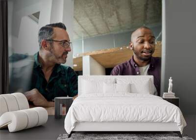 Two diverse business colleagues working together on a laptop Wall mural