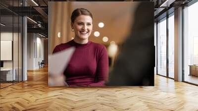 Young businesswoman smiling during a meeting with office colleagues Wall mural