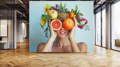 The concept of a healthy lifestyle and proper nutrition. Girl with fruit on her face and hair. Background with copy space for advertising food, vitamins, juices. Wall mural