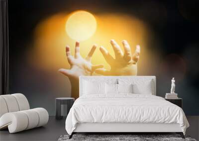 baby hands raised at sunset. Wall mural