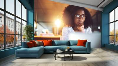 Black woman, thinking and night with laptop or glasses for business decision or project deadline at office. Young African, female person or employee working late in wonder or contemplating choice Wall mural