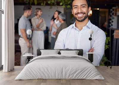 Portrait, smile and a professional business man in the office, standing arms crossed with his team in the background. Corporate, happy and confident with a young male employee at a work function Wall mural