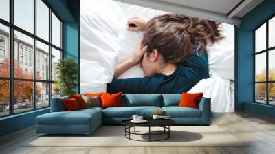 young woman in bed holding her head Wall mural