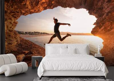 Young man silhouette in a coastal cave next to Hendaia beach, at the Basque Country. Wall mural