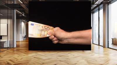 Banknotes of money in hand on black background Wall mural