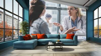 doctor in a medical office talking to a patient about her brain health and well-being. Wall mural