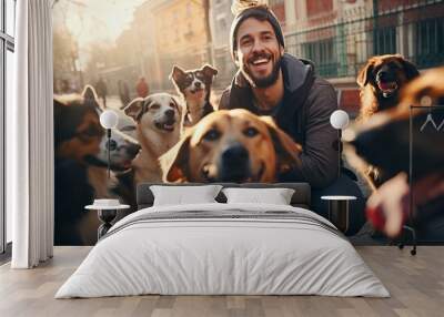 smiling male volunteer among friendly dogs on the street Wall mural