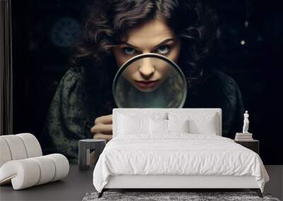 woman looking through a magnifying glass Wall mural