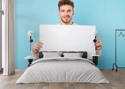 young man holding a blank sign in his hands Wall mural