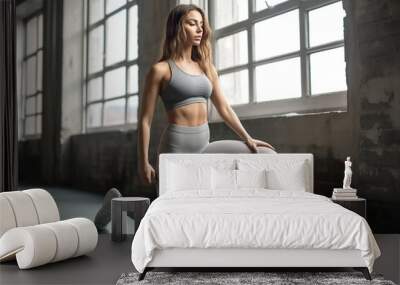 young woman is doing squats in the modern gym Wall mural