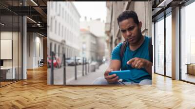 Latin tourist man in Europe with his smartphone Wall mural