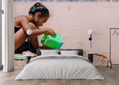 young girl playing in sand of beach on island of Tenerife Spain Wall mural