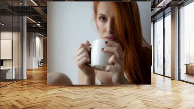 young ginger woman with cup of coffee Wall mural