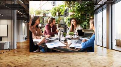 Creative, ideas and people in cafe for planning, strategy and online startup project development with teamwork. Collaboration, men and women in coffee shop with laptop, paperwork and design meeting Wall mural