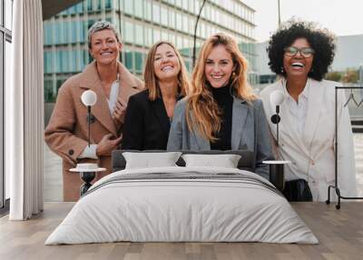 Group of proud businesswomen smiling and looking at camera at workplace. Real executive women staring front, laughing together with suit and successful expression. Corporate female employees meeting Wall mural