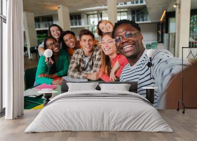 Happy young students taking a selfie portrait together at university library. African american guy shooting a photo with his smiley classmates on a high school meeting. Friends at academy. friendship Wall mural