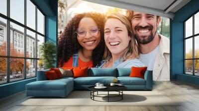 Vertical portrait. Group of young adult friends smiling taking a selfie portrait and having fun together. Group of people celebrating their friendship. Two women and one man with positive expression Wall mural