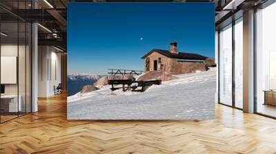 Casa en montaña con nieve, atardecer Wall mural