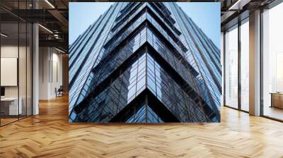 Modern skyscrapper with glass facade under clear blue sky Wall mural