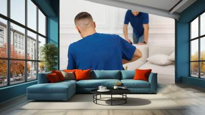 Two man from cleaning company working hard on cleaning sofa Wall mural