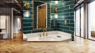 A bathroom with green subway tile walls, gold lights, marble sink and a gold faucet. Wall mural