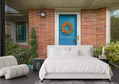 A front door detail with red brick siding, a light blue front door, and a covered porch. Wall mural