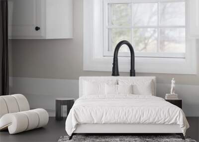 A kitchen sink detail with a black faucet, white cabinets, and marble countertop. Wall mural