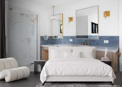 A luxurious bathroom with a wood vanity cabinet, blue tiles on the walls, gold accented lights and mirrors, and a large walk-in shower lined with marble tiles. No brands or labels. Wall mural