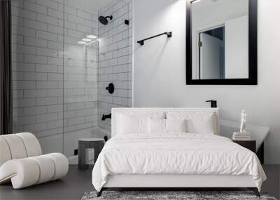 A small modern bathroom with a dark vanity, mirror frame, and hardware. White subway tiles line the bathtub and shower with black faucets. Wall mural