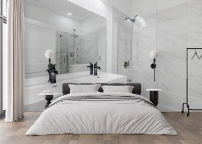 An all white master bathroom with black hardware and faucets showing the vanity and shower with the door open. The shower has glass walls/door and beautiful tiles. Wall mural