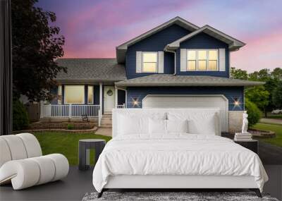 Exterior of a suburban home with blue siding, a white front porch, and white shutters at sunset.	 Wall mural