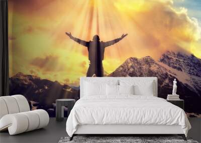 Man Praying With Arms Open On Epic Mountain Top Summit With Light Shining With Arms Out On Top Of Mountain Peak	 Wall mural