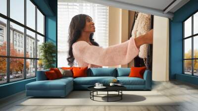 african american woman looking through closet in bedroom at home Wall mural