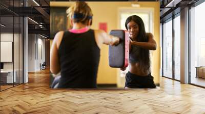 african american woman tolding target pad for boxing training Wall mural