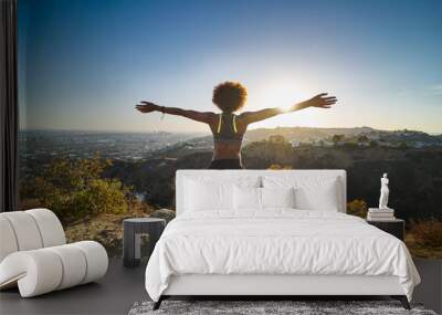 athletic african american woman celebrating reaching top of runyon canyon with arms open Wall mural